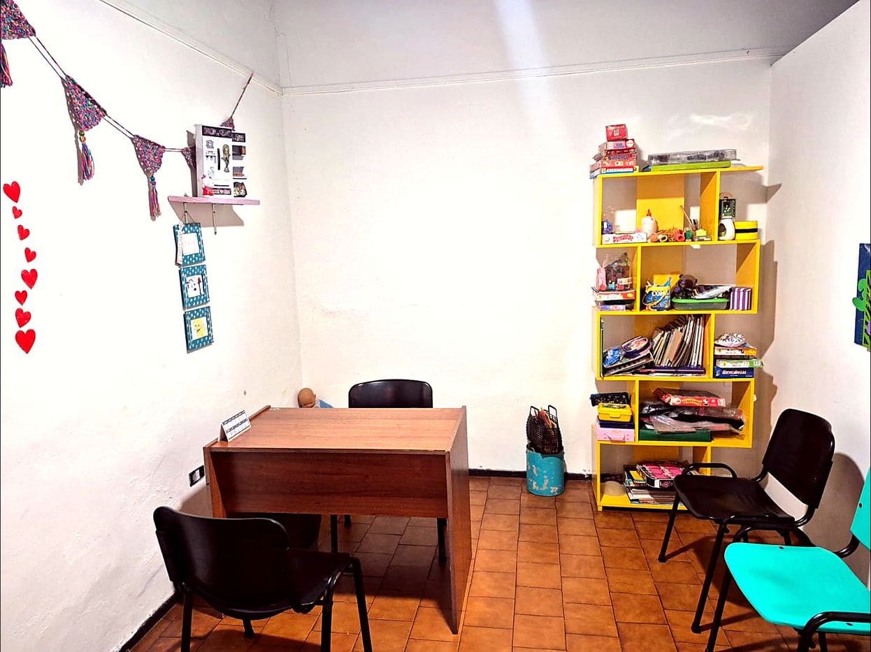 Consultorio de AZAI con escritorio y biblioteca de juegos