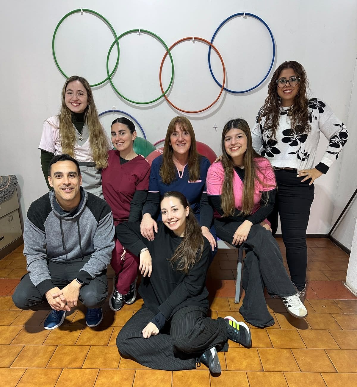 Equipo de profesionales de AZAI reunido en una sala del centro, frente a aros de colores