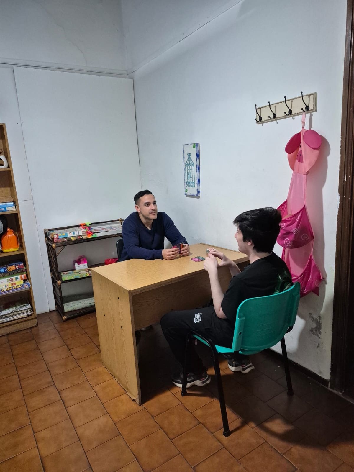 Psicólogo de AZAI jugando a las cartas con un paciente en el consultorio