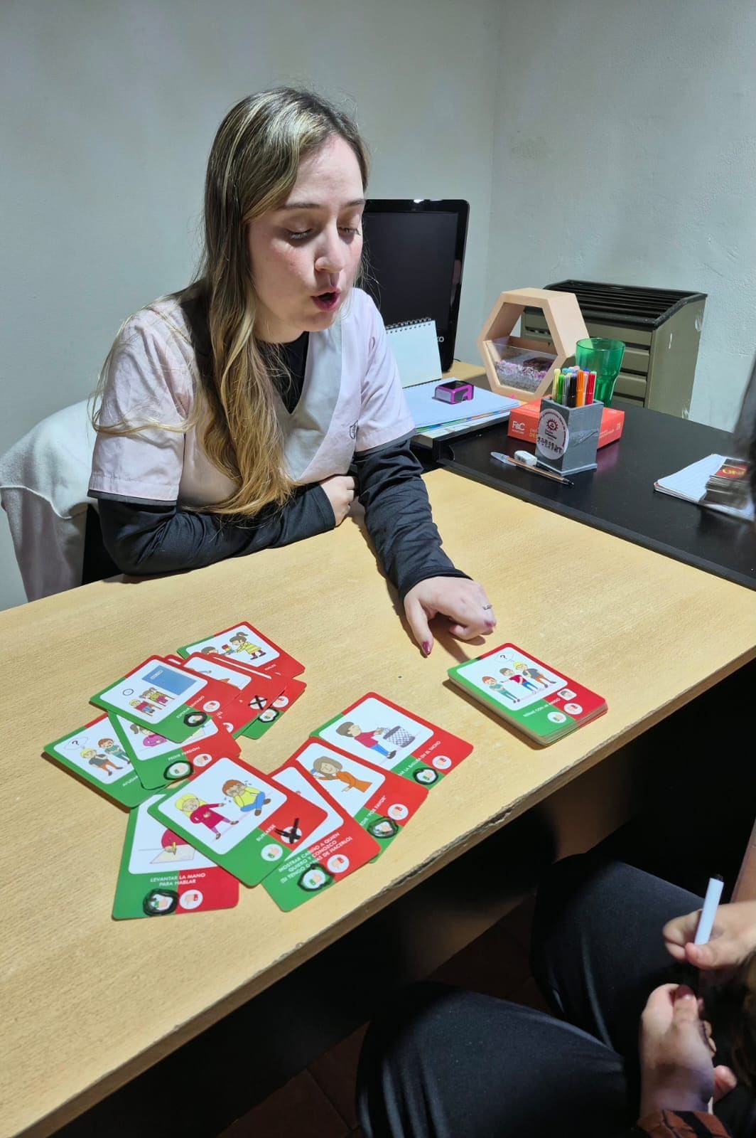 Psicóloga de AZAI trabajando con tarjetas de situaciones junto a un paciente